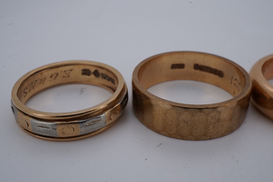 Four gold rings, comprising: a 22ct gold wedding band, size M, British assay marks, gross weight 3 grams; a 9ct gold band with a panelled finish, size N, British hallmarks, gross weight approximately 3.5 grams; a bicolou